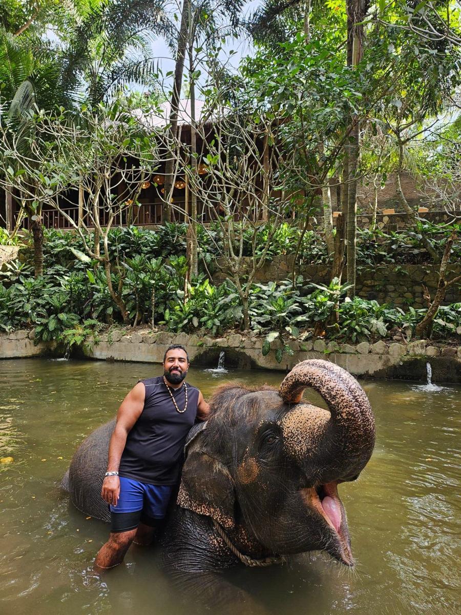Younes dans l'eau aux côtés d'un éléphant de Borneo à Lombok, Indonésie