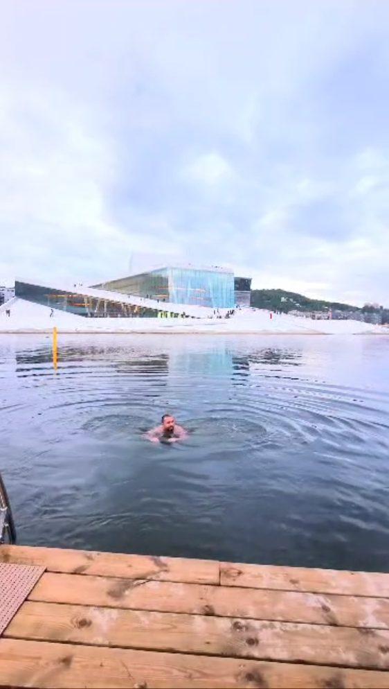 Younes nageant dans le fjord devant l'Opéra d'Oslo, Norvège